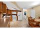 Kitchen with wood cabinets, white appliances, and adjacent laundry at 7504 Cypress Knee Dr, Hudson, FL 34667
