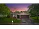 House exterior at dusk with landscaping and garage at 7504 Cypress Knee Dr, Hudson, FL 34667