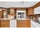 Kitchen with wood cabinets, white appliances, and view of the pool at 7504 Cypress Knee Dr, Hudson, FL 34667