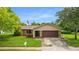 Tan one-story home with brown garage door at 7504 Cypress Knee Dr, Hudson, FL 34667