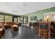 Bright sunroom featuring a large sectional sofa and a wet bar at 7504 Cypress Knee Dr, Hudson, FL 34667
