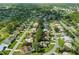 Wide aerial view of a residential area with a lake and various housing styles at 9410 Fox Hollow Ln, Weeki Wachee, FL 34613