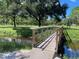 Wooden footbridge crossing a tranquil waterway, nestled within a scenic park-like setting at 6642 Stewart N Ave, St Petersburg, FL 33702