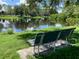 Park bench overlooking a serene pond, perfect for relaxation and enjoying nature at 6642 Stewart N Ave, St Petersburg, FL 33702
