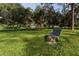 Park bench underneath a tree in a lush green park setting at 6642 Stewart N Ave, St Petersburg, FL 33702