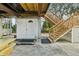 Unfinished basement area with storage shed and wooden stairs at 14904 Old Dixie Hwy, Hudson, FL 34667