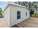 Tan vinyl-sided house with a wooden deck and landscaping at 14904 Old Dixie Hwy, Hudson, FL 34667
