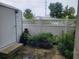 Small side yard with white fence, potted plants, and a storage shed, adding privacy and charm at 14904 Old Dixie Hwy, Hudson, FL 34667