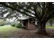 Rustic horse stable nestled under a large oak tree at 23337 Lake Lindsey Rd, Brooksville, FL 34601