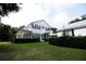 Two story house with white siding, black windows, and a large front porch at 23337 Lake Lindsey Rd, Brooksville, FL 34601
