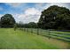 Long wooden fence bordering a lush green pasture at 23337 Lake Lindsey Rd, Brooksville, FL 34601