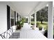 Long front porch with white columns, black shutters, and potted plants at 23337 Lake Lindsey Rd, Brooksville, FL 34601