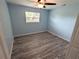 Simple bedroom with light blue walls and wood-look flooring at 27299 Azen Loop, Brooksville, FL 34602