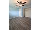 Light blue bedroom with wood-look floors and a ceiling fan at 27299 Azen Loop, Brooksville, FL 34602