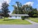 White house with carport and spacious lawn at 27299 Azen Loop, Brooksville, FL 34602