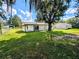 House exterior with large backyard and mature trees at 27299 Azen Loop, Brooksville, FL 34602