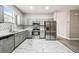 Modern kitchen featuring gray cabinets, stainless steel appliances, and marble-look flooring at 12113 Colony Lakes Blvd, New Port Richey, FL 34654