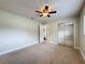 Bright bedroom with carpeted floor, ceiling fan, and mirrored closet doors at 5481 Nodoc Rd, Spring Hill, FL 34609