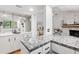 Kitchen with granite countertop, white cabinets and view of living room with fireplace at 303 Old Mill Pond Rd # 303, Palm Harbor, FL 34683