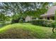 Landscaped backyard with pond view and lush greenery at 303 Old Mill Pond Rd # 303, Palm Harbor, FL 34683