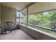 Relaxing screened porch with a hanging chair and leafy views at 303 Old Mill Pond Rd # 303, Palm Harbor, FL 34683