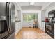 Bright kitchen with white cabinets, black appliances, and wood-look floors at 303 Old Mill Pond Rd # 303, Palm Harbor, FL 34683