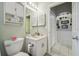 Clean bathroom with a toilet, sink, and wall-mounted cabinet at 13444 Norman Cir, Hudson, FL 34669