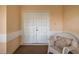 Front porch with white double doors and wicker chair at 1218 Gillespie N Dr, Palm Harbor, FL 34684