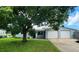 Ranch style home with a large tree in the front yard at 3814 Holiday Lake Dr, Holiday, FL 34691