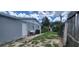 Rear exterior view of the house, showing a white door and grassy area at 3814 Holiday Lake Dr, Holiday, FL 34691