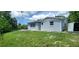 House exterior with gray siding, a shed, and a grassy backyard at 3814 Holiday Lake Dr, Holiday, FL 34691