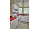 Bright kitchen with white cabinets, red countertops, and tile flooring at 2077 Wetland Pt # 1103, Lutz, FL 33558