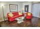 Well lit living room with red furniture, decorative mirror and coffee table at 2077 Wetland Pt # 1103, Lutz, FL 33558