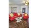Well lit living room with red furniture, a glass coffee table and unique decor at 2077 Wetland Pt # 1103, Lutz, FL 33558