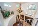 Grand staircase with wrought-iron railing and chandelier at 9943 Milano Dr, Trinity, FL 34655