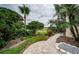 Landscaped backyard with a brick patio and golf course view at 9943 Milano Dr, Trinity, FL 34655