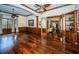Large office with hardwood floors, built-in shelving, and ceiling fan at 9943 Milano Dr, Trinity, FL 34655