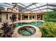 Resort-style pool and spa with screened enclosure and lush landscaping at 9943 Milano Dr, Trinity, FL 34655