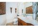 Elegant bathroom with wood vanity, large mirror, and decorative wall art at 9943 Milano Dr, Trinity, FL 34655