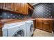 Laundry room with wooden cabinetry, copper countertops, and modern Bosch washer and dryer at 9943 Milano Dr, Trinity, FL 34655