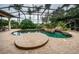 Large, freeform pool and spa with a screened enclosure and lush landscaping at 9943 Milano Dr, Trinity, FL 34655