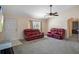 Living room featuring red leather couches, a ceiling fan, and a large TV at 4336 Lightfoot St, Spring Hill, FL 34609