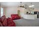 Living room with red reclining sofas, ceiling fan, and view into the kitchen at 4336 Lightfoot St, Spring Hill, FL 34609