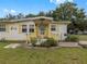 Front view of a yellow house with wooden steps and deck at 9140 & 9130 Peony St, New Port Richey, FL 34654
