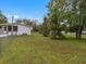 Home's exterior side yard with mature trees at 9140 & 9130 Peony St, New Port Richey, FL 34654