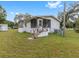 Home's exterior view with wooden steps and screened porch at 9140 & 9130 Peony St, New Port Richey, FL 34654