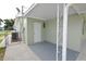 Covered side patio with gray floor and storage access at 4607 Nimmer Dr, New Port Richey, FL 34652