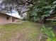 Spacious backyard featuring mature trees, a patio area, and ample green space for outdoor activities and relaxation at 7206 Ashwood Dr, Port Richey, FL 34668