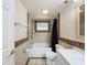 Bathroom with a tub, shower, tiled walls, vanity with sink, toilet, and fixtures at 7206 Ashwood Dr, Port Richey, FL 34668