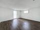 Bright bedroom features wood-look flooring, natural light from windows, and a sliding glass door at 7206 Ashwood Dr, Port Richey, FL 34668
